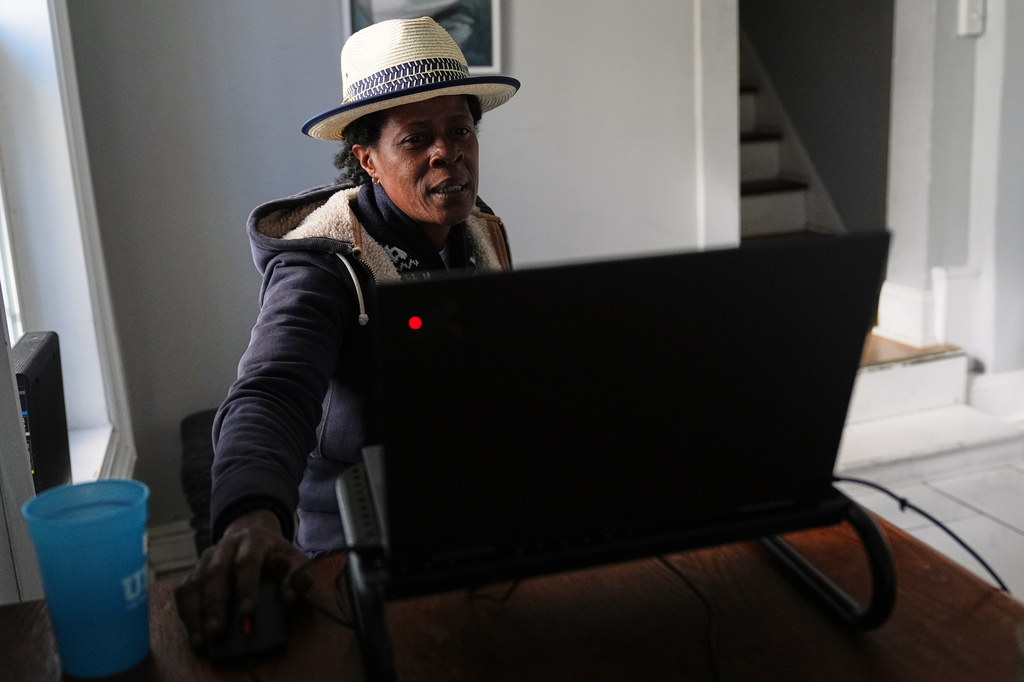 Jevona Anderson, a student at the University of Baltimore, reviews online assignments in her home Tuesday, April 7, 2026, in Baltimore. (AP Photo/Stephanie Scarbrough)