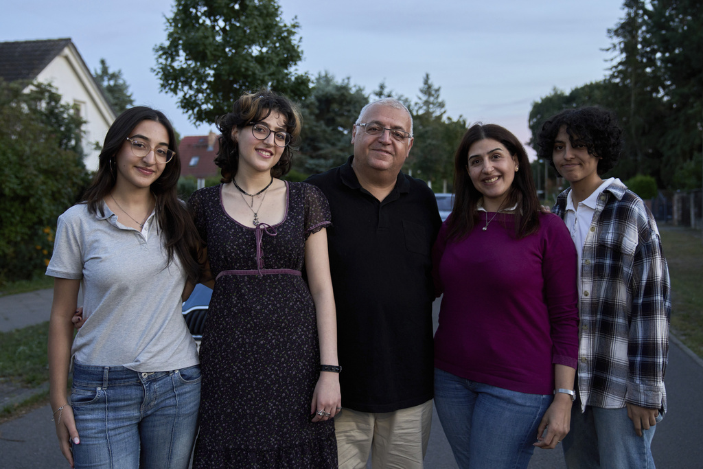 Family members Razan Wahbeh, 17, Rajaa Wahbeh, 20, Basem Wahbeh, 52, Rahaf Alshaar, 44, and Raneen Wahbeh, 13, pose for a photo in front of their house in Berlin on Aug. 25, 2025. (AP Photo/Ebrahim Noroozi)