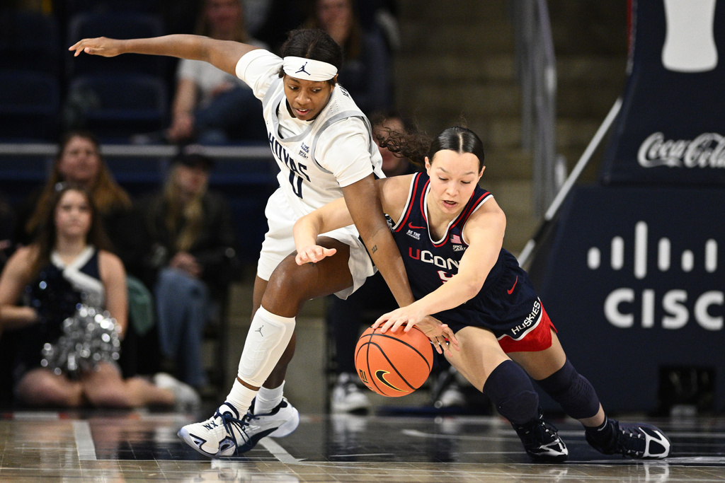 UConn guard Kayleigh Heckel, right, and Georgetown guard Laila Jewett, left, battle for the ball during the first half of an NCAA college basketball game, Thursday, Jan. 22, 2026, in Washington. (AP Photo/Nick Wass)