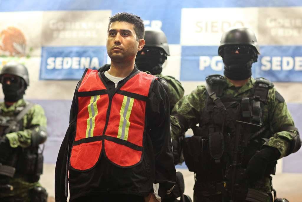 FILE - Soldiers stand guard over Erick Valencia Salazar, alias "El 85,", in Mexico City, March 12, 2012. (AP Photo/Alexandre Meneghini, File)