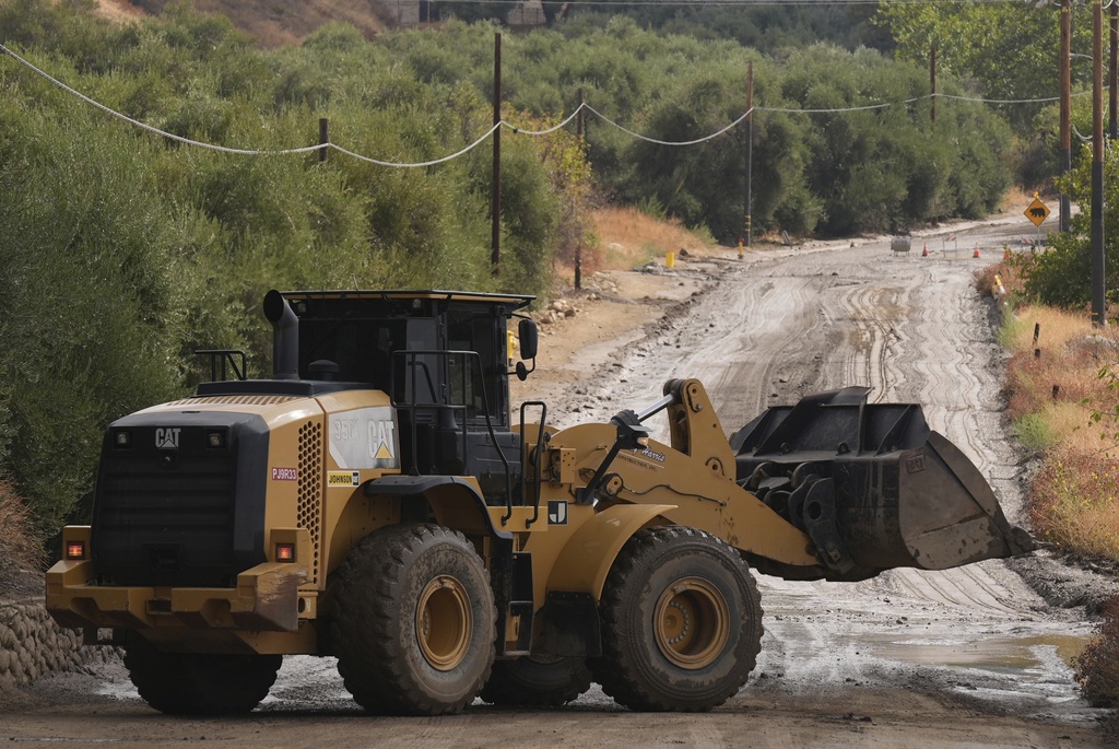 Workers clean up the damage caused by mudslides after storms in Yucaipa, Calif., Friday, Sept. 19, 2025. (AP Photo/Damian Dovarganes)
