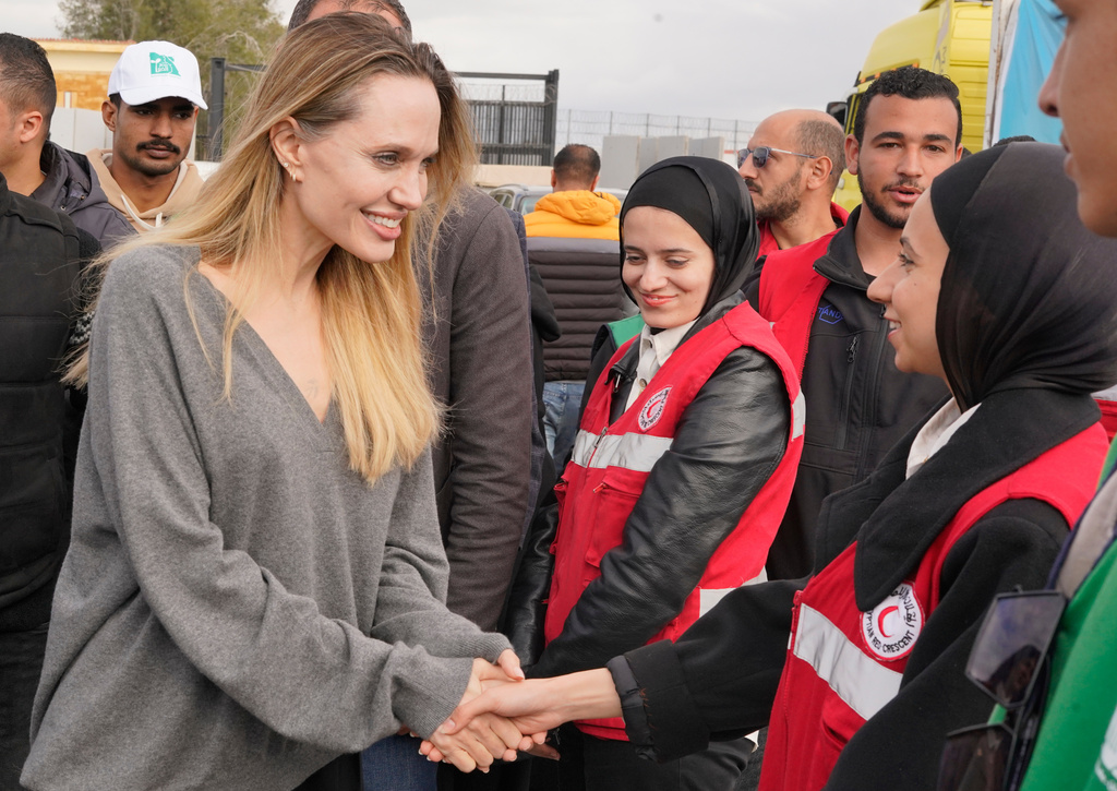 American actor and film producer Angelina Jolie, front left, greets Red Crecent workers during her visit to the Rafah border crossing between Egypt and the Gaza Strip in Rafah, Egypt, Friday, Jan. 2, 2026. (AP Photo/Mohamed Arafat)