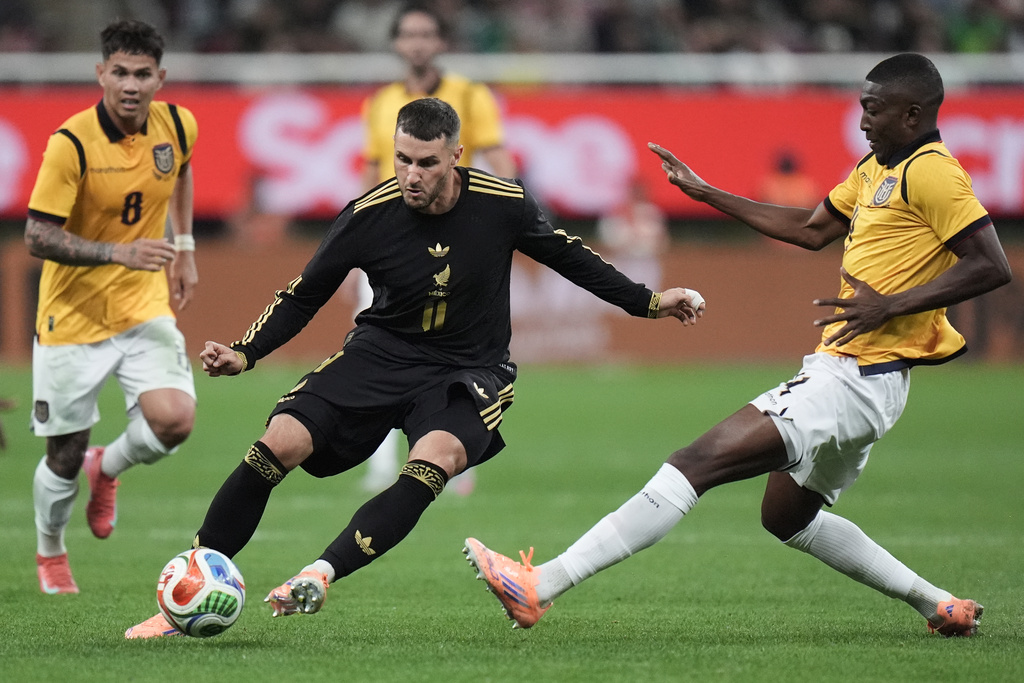 Mexico's Santiago Gimenez, center, is challenged by Ecuador's Joel Ordóñez, right, during a friendly soccer match at Akron stadium in Guadalajara, Mexico, Tuesday, Oct. 14, 2025. (AP Photo/Eduardo Verdugo)