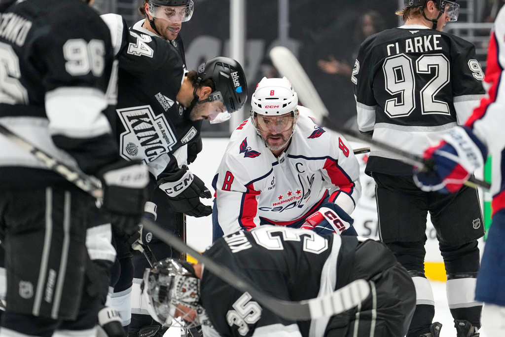 Washington Capitals left wing Alex Ovechkin, second from right, waits for the puck to come loose as Los Angeles Kings left wing Andrei Kuzmenko, left, center Anze Kopitar, second from left, center Phillip Danault, third from left, goaltender Darcy Kuemper, below, and defenseman Brandt Clarke stand by during the first period of an NHL hockey game Tuesday, Dec. 2, 2025, in Los Angeles. (AP Photo/Mark J. Terrill)