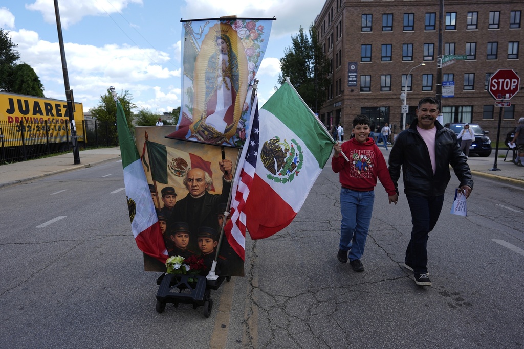 People walks along the route during the 2025 Pilsen Mexican Independence Day parade Saturday, Sept. 6, 2025, in Chicago. (AP Photo/Carolyn Kaster)