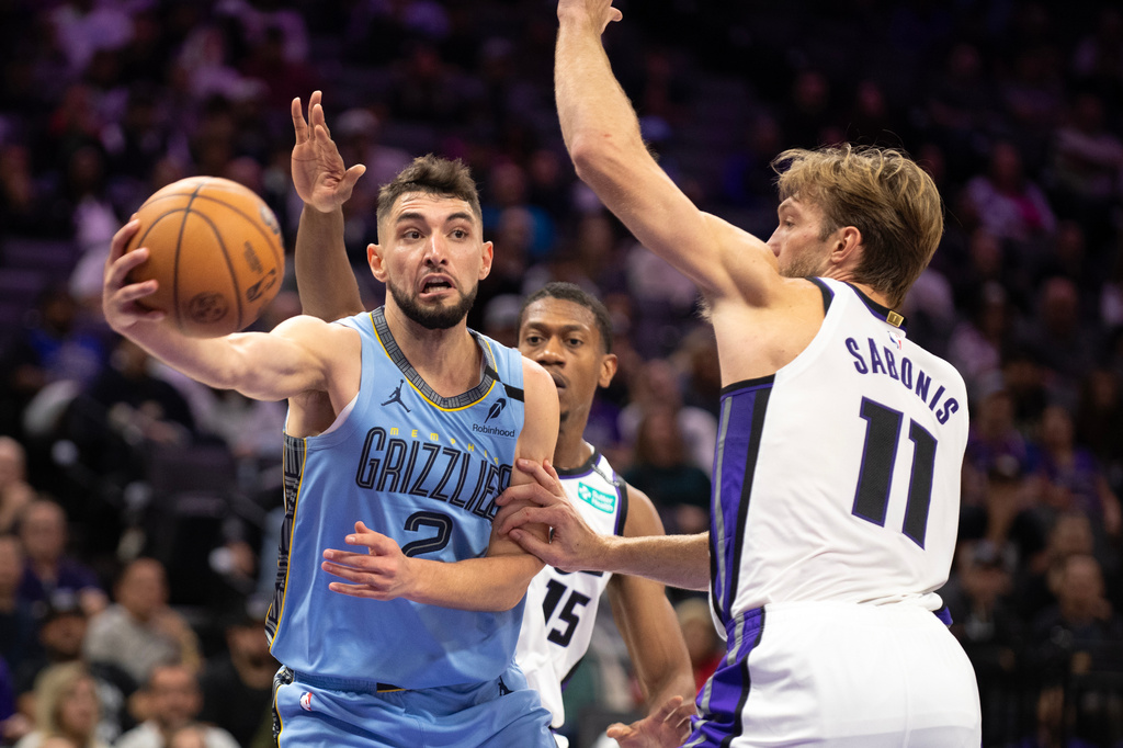Memphis Grizzlies guard Ty Jerome (2) makes a pass as Sacramento Kings forward Domantas Sabonis (11) defends during the first half of an NBA basketball game on Sunday, Oct. 25, 2026, in Sacramento, Calif. (AP Photo/Jose Luis Villegas)