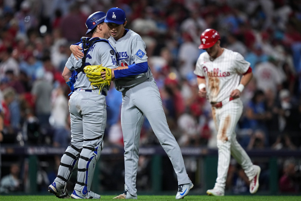 Los Angeles Dodgers' Will Smith, left, and Roki Sasaki celebrate after the Dodgers won Game 1 of baseball's National League Division Series against the Philadelphia Phillies, Saturday, Oct. 4, 2025, in Philadelphia. (AP Photo/Matt Slocum)
