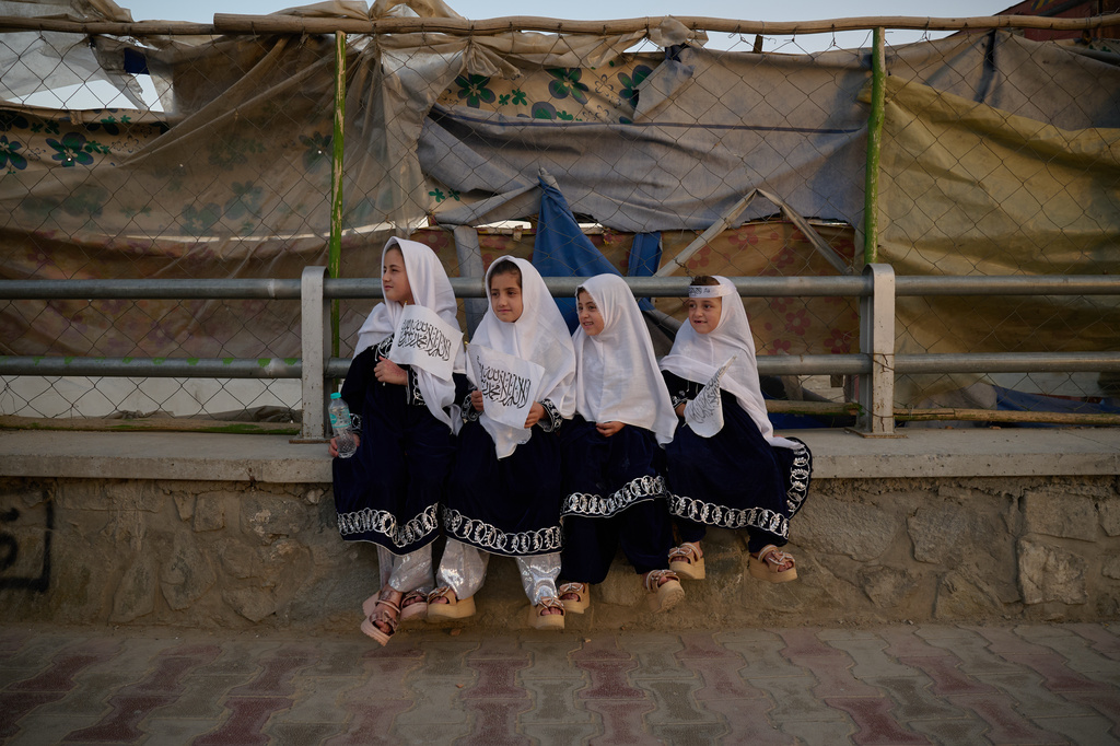 Four young girls dressed in matching outfits hold Taliban flags on the eve of the fifth anniversary of the U.S. withdrawal and the start of Taliban rule in Kabul, Afghanistan, Friday, Aug. 14, 2026. (AP Photo/Nava Jamshidi)