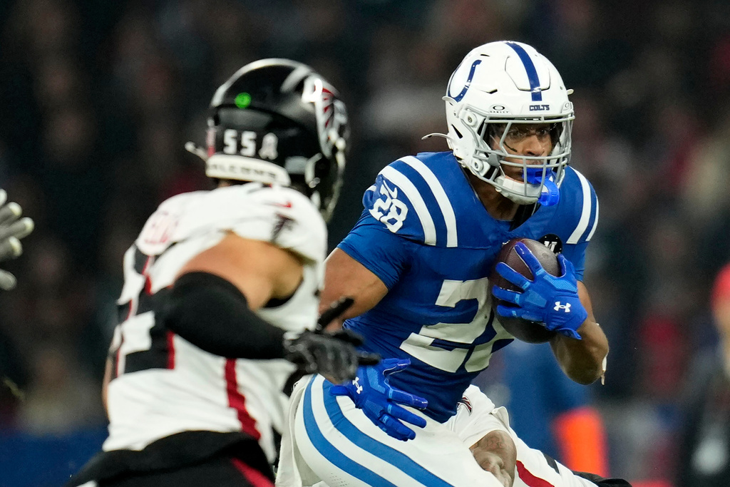 Indianapolis Colts running back Jonathan Taylor (28) runs from Atlanta Falcons linebacker Kaden Elliss (55) during the first half of an NFL football game, Sunday, Nov. 9, 2025, in Berlin, Germany. (AP Photo/Ebrahim Noroozi)