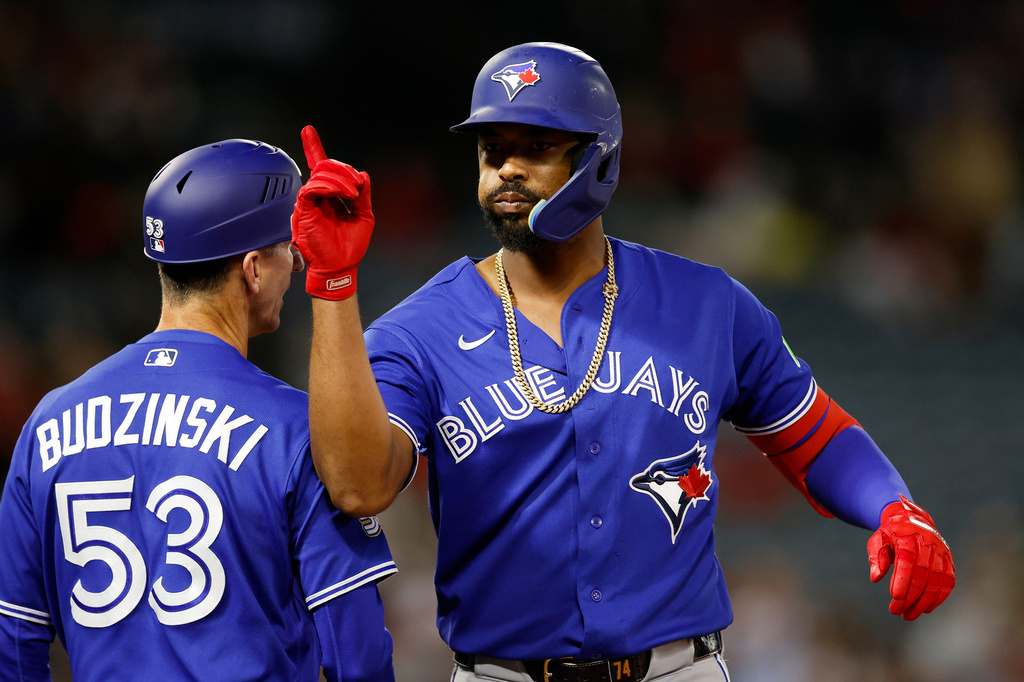 Toronto Blue Jays designated hitter Eloy Jiménez (74) reacts after a single that scored Davis Schneider (36) during the eighth inning of a baseball game Tuesday, April 21, 2026, in Anaheim, Calif. (AP Photo/Caroline Brehman)