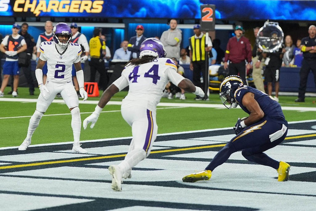 Los Angeles Chargers wide receiver Tre Harris (9) catches a touchdown pass ahead of Minnesota Vikings safety Josh Metellus (44) during the second half of an NFL football game Thursday, Oct. 23, 2025, in Inglewood, Calif. (AP Photo/Gregory Bull)