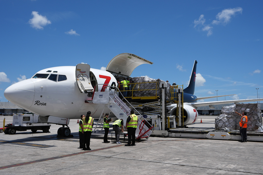 People load pallets containing food and hygiene kits for a humanitarian assistance flight to Cuba organized by the Trump administration as the U.S. continues to put pressure on the island's government, Tuesday, July 21, 2026, in Miami. (AP Photo/Lynne Sladky)