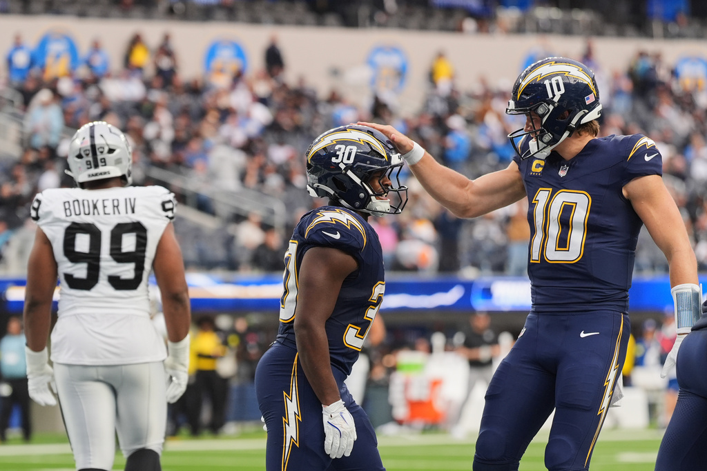 Los Angeles Chargers running back Kimani Vidal (30) celebrates with quarterback Justin Herbert (10) after scoring a touchdown during the second half of an NFL football game against the Las Vegas Raiders, Sunday, Nov. 30, 2025, in Inglewood, Calif. (AP Photo/Jae C. Hong)