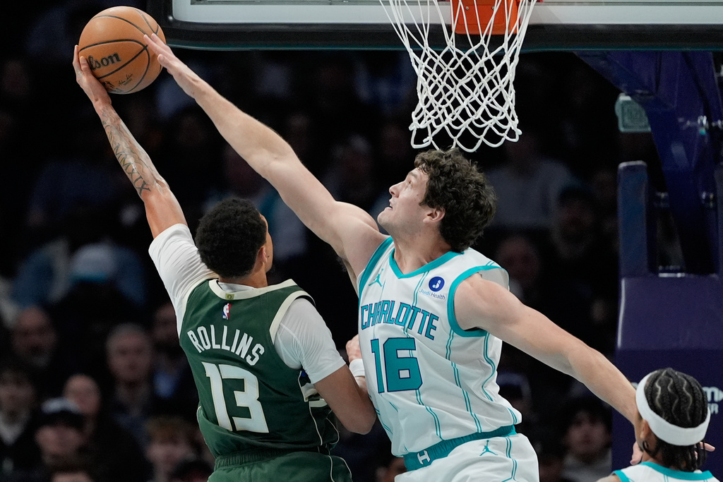 Charlotte Hornets' PJ Hall blocks a shot by Milwaukee Bucks guard Ryan Rollins during the first half of an NBA basketball game, Monday, Dec. 29, 2025, in Charlotte, N.C. (AP Photo/Chris Carlson)