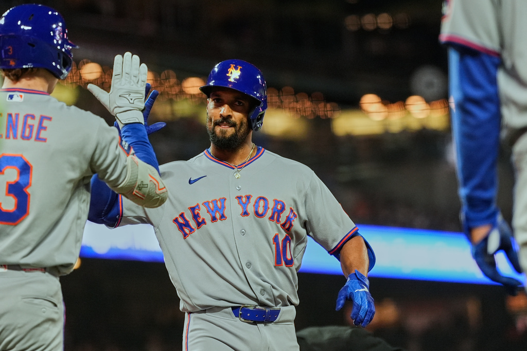 New York Mets' Marcus Semien, center, celebrates with Carson Benge, left, after hitting a two-run home run during the fourth inning of a baseball game against the San Francisco Giants, Friday, April 3, 2026, in San Francisco. (AP Photo/Godofredo A. Vásquez)