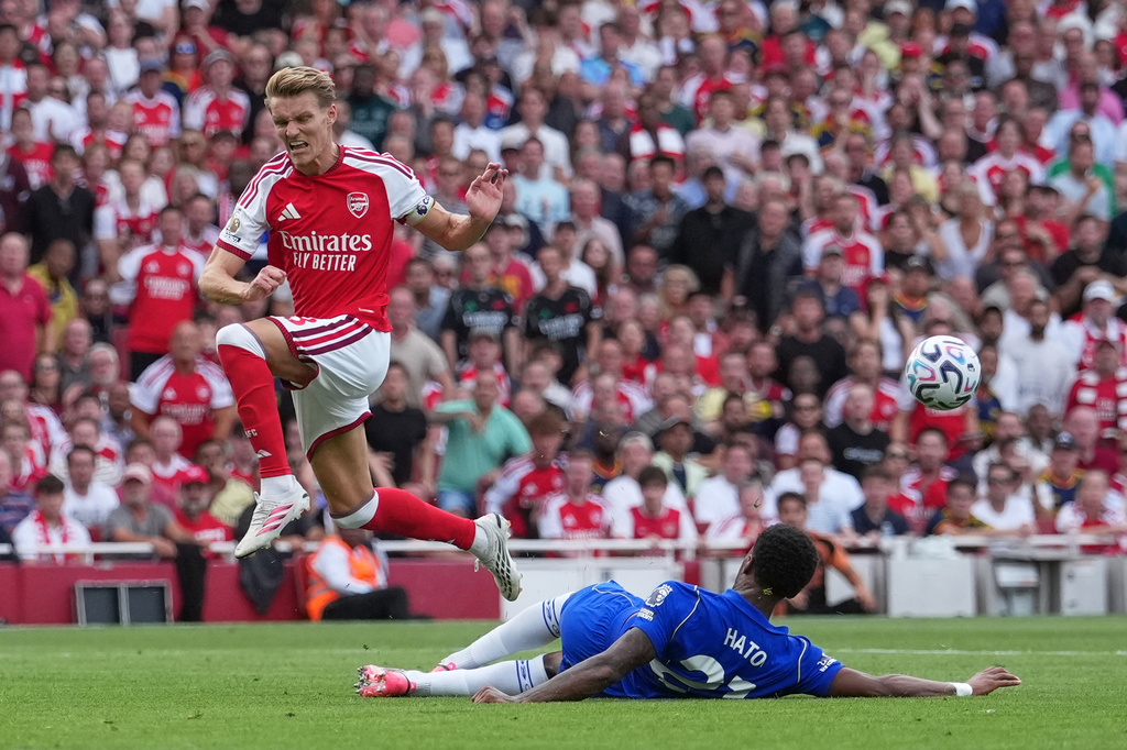 Chelsea's Jorrel Hato, bottom, and Arsenal's Martin Odegaard in action during the English Premier League soccer match between Arsenal and Chelsea in London, Sunday, Sept. 6, 2026. (AP Photo/Dave Shopland)