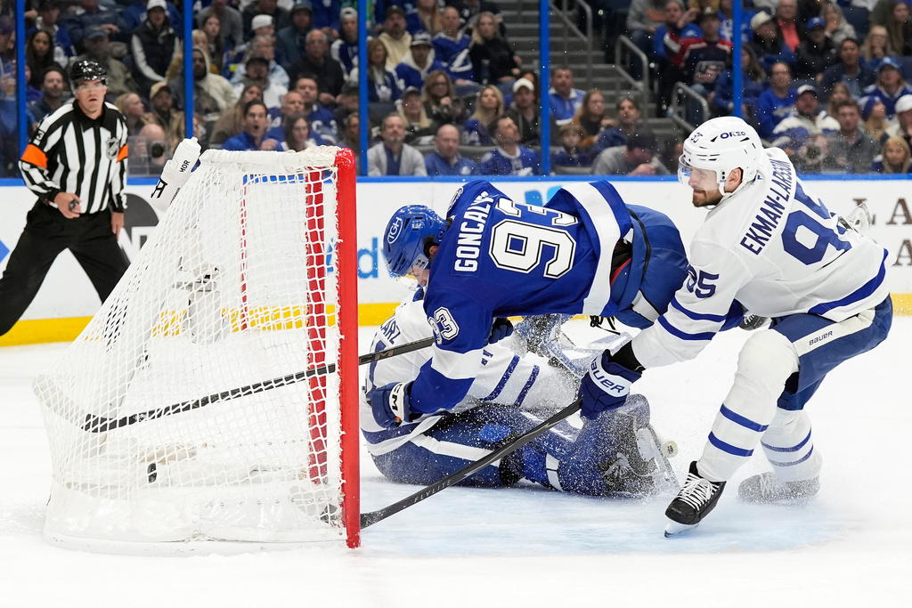 Tampa Bay Lightning center Gage Goncalves (93) gets tripped up by Toronto Maple Leafs defenseman Oliver Ekman-Larsson (95) after scoring past goaltender Anthony Stolarz (41) during the second period of an NHL hockey game Wednesday, Feb. 25, 2026, in Tampa, Fla. (AP Photo/Chris O'Meara)