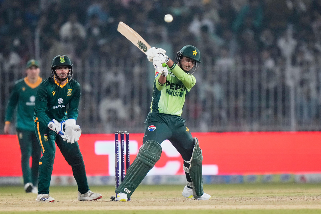 Pakistan's Saim Ayub, center, plays a shot as South Africa's Quinton de Kock, second left, watches during the third one day international cricket match between Pakistan and South Africa, in Faisalabad, Pakistan, Saturday, Nov. 8, 2025. (AP Photo/Anjum Naveed)