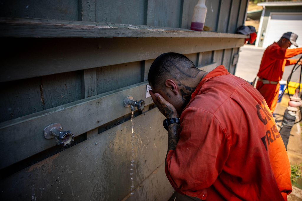 Damien Rubalcava washes his face after work at the Pine Grove Youth Conservation Camp, July 14, 2025, in Red Corral, Calif. (AP Photo/Ethan Swope)