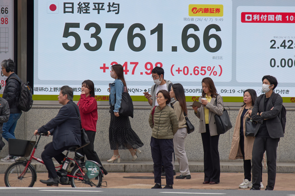 People stand in front of an electronic stock board showing Japan's Nikkei index at a securities firm Tuesday, April 7, 2026, in Tokyo. (AP Photo/Eugene Hoshiko)