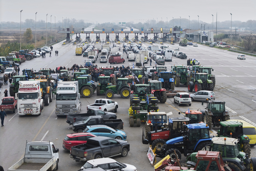 Farmers and supporters block a highway at the Malgara toll stations near Thessaloniki, northern Greece, on Wednesday, Dec. 3, 2025, during a protest over delays in farm subsidy payments. (AP Photo/Giannis Papanikos)