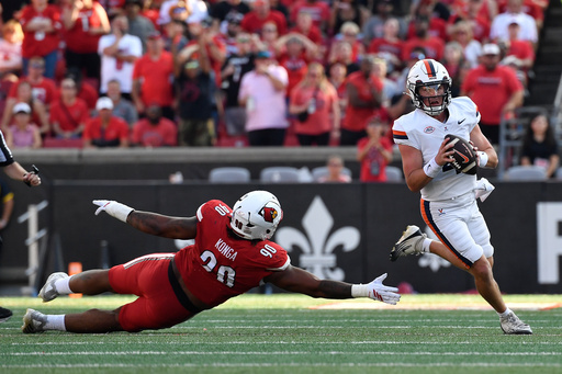 Virginia quarterback Chandler Morris (4) avoids the reach of Louisville Cardinals defensive lineman Rene Konga (90) during the second half of an NCAA college football game in Louisville, Ky., Saturday, Oct. 4, 2025. (AP Photo/Timothy D. Easley) Virginia quarterback Chandler Morris (4) avoids the reach of Louisville Cardinals defensive lineman Rene Konga (90) during the second half of an NCAA college football game in Louisville, Ky., Saturday, Oct. 4, 2025. (AP Photo/Timothy D. Easley)