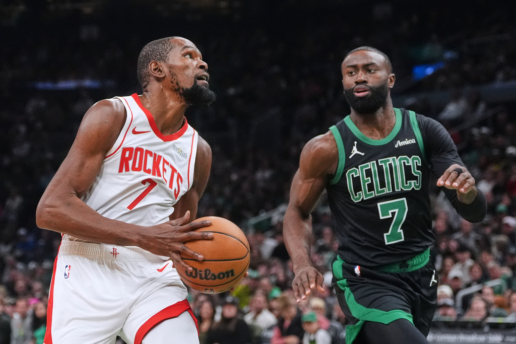 Houston Rockets forward Kevin Durant, left, drives to the basket against Boston Celtics forward Jaylen Brown during the first half of an NBA basketball game, Saturday, Nov. 1, 2025, in Boston. (AP Photo/Charles Krupa)