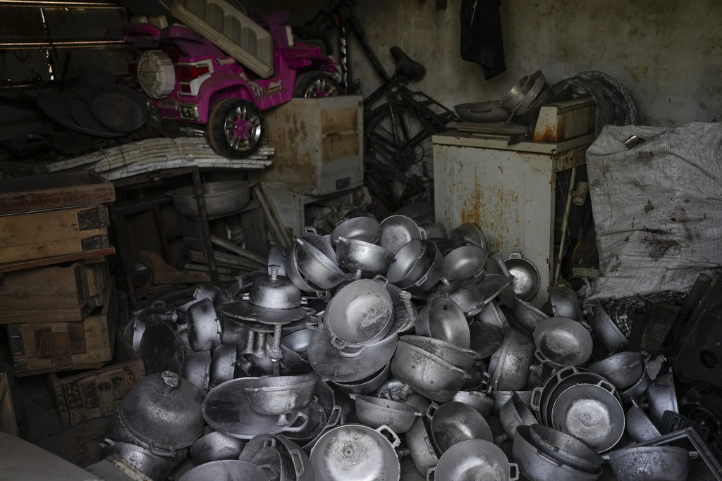 Aluminum pots made by the Romero Perez family, who returned to Venezuela from Mexico after abandoning plans to reach the United States amid President Donald Trump's migration crackdown, sit in a pile at their workshop in Maracaibo, Venezuela, Monday, June 16, 2025. (AP Photo/Matias Delacroix)