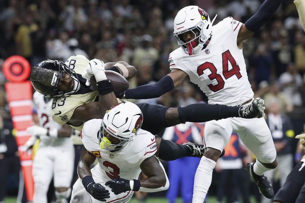 Arizona Cardinals safety Jalen Thompson (34) and Cardinals safety Budda Baker (3) break up a pass intended for New Orleans Saints tight end Juwan Johnson (83) during the second half of an NFL football game Sunday, Sept. 7, 2025, in New Orleans. (AP Photo/Butch Dill)