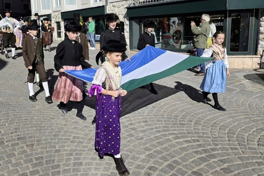 In this undated handout photo, people carry a traditional Ladin flag during a parade through the streets of Cortina D'Ampezzo, northern Italy, Monday, Jan. 26, 2026. (ULdA, Ampezzo Ladin Union via AP)