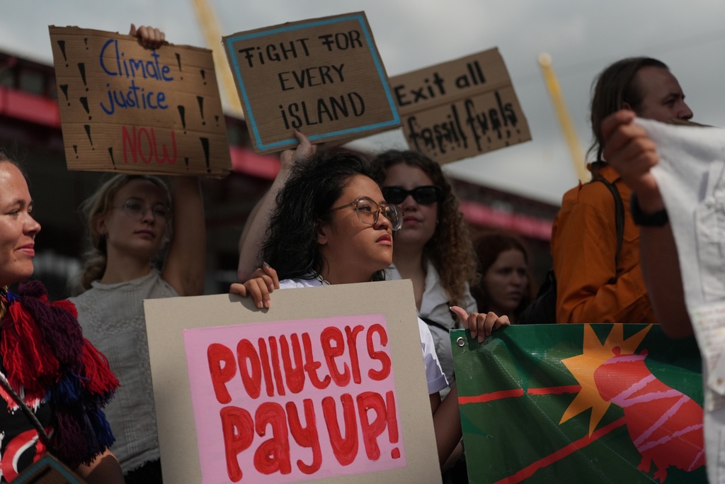 ADDS NAME - Rachelle Junsay, center, stands with other activists participating in a youth climate demonstration during the COP30 U.N. Climate Summit, Friday, Nov. 14, 2025, in Belem, Brazil. (AP Photo/Joshua A. Bickel)