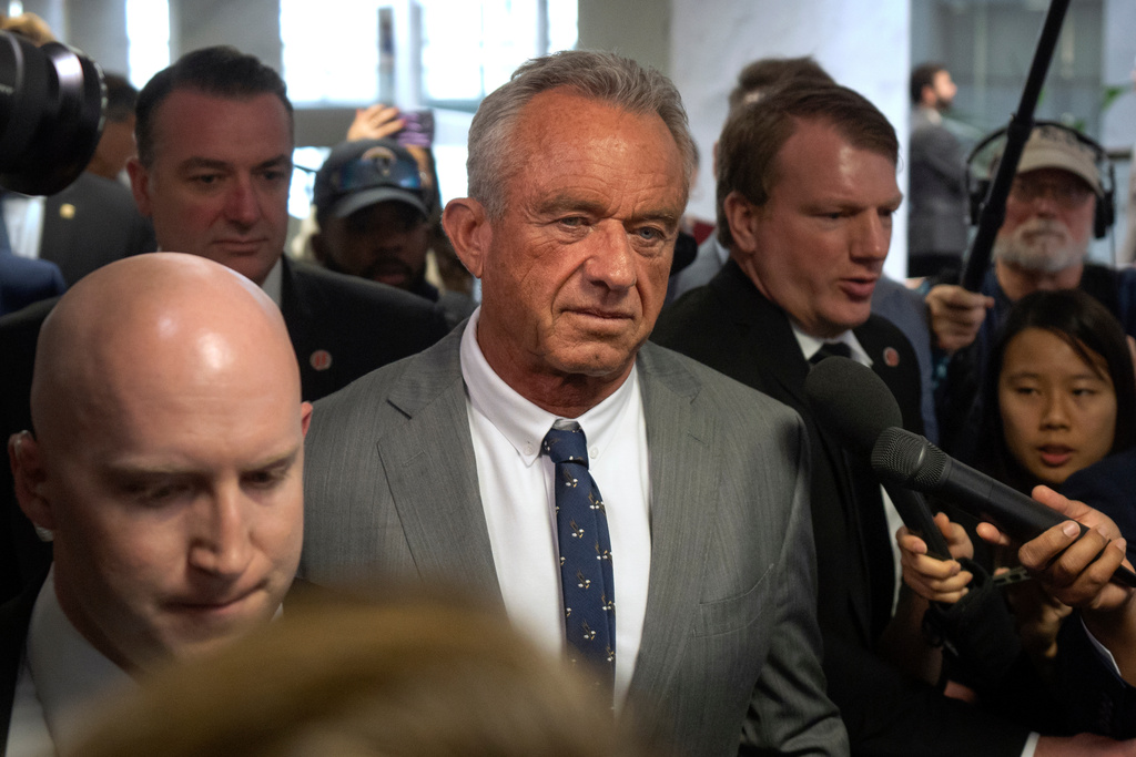 FILE - Robert Kennedy Jr., center, President-elect Donald Trump's pick to lead the Health and Human Services Department, walks between meetings with senators on Capitol Hill, Tuesday, Dec. 17, 2024, in Washington. (AP Photo/Mark Schiefelbein, File)