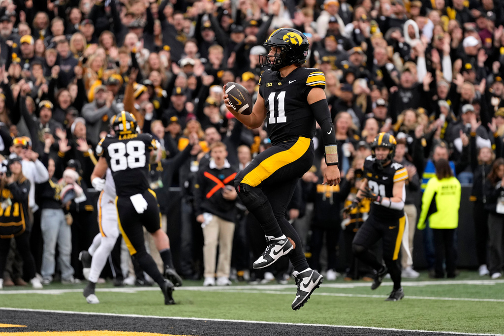 Iowa quarterback Mark Gronowski leaps into the end zone during a touchdown run in the first half of an NCAA college football game against Minnesota, Saturday, Oct. 25, 2025, in Iowa City, Iowa. (AP Photo/Charlie Neibergall)