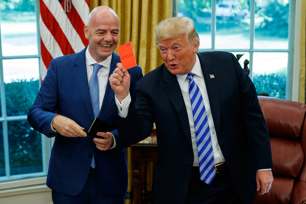 FILE - President Donald Trump holds up a red card during a meeting with FIFA president Gianni Infantino in the Oval Office of the White House, Tuesday, Aug. 28, 2018, in Washington. (AP Photo/Evan Vucci, File)