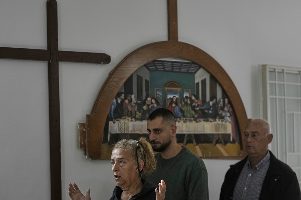 Worshippers attend Sunday Mass inside a room usually used as a residence for visiting bishops next to St. George Melkite Catholic Church, which was destroyed in an Israeli airstrike, in the town of Dardghaya, southern Lebanon, Sunday, Nov. 16, 2025. (AP Photo/Hassan Ammar)