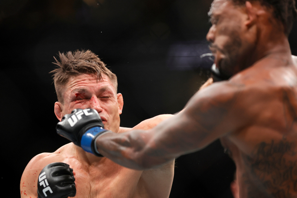 Drew Dober, left, connects with a punch that knocks down Michael Johnson, right, in the second round of a lightweight mixed martial arts bout during UFC 326, Saturday, March 7, 2026, in Las Vegas. (Steve Marcus/Las Vegas Sun via AP)