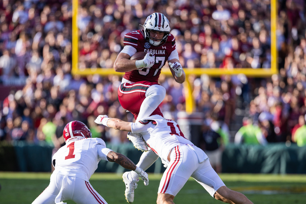 South Carolina tight end Brady Hunt (87) tries to leap over Alabama defensive lineman Jordan Renaud (11) during the first half of an NCAA college football game, Saturday, Oct. 25, 2025, in Columbia, S.C. (AP Photo/Scott Kinser)