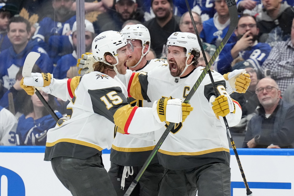 Vegas Golden Knights' Jack Eichel (9), Noah Hanifin (15) and Mark Stone (61) celebrate after a goal against the Toronto Maple Leafs during third-period NHL hockey game action in Toronto, Friday, Jan. 23, 2026. (Nathan Denette/The Canadian Press via AP)