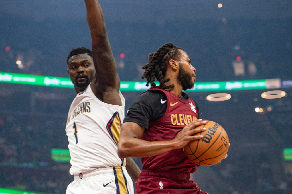 Cleveland Cavaliers' Darius Garland, right, keeps the ball from New Orleans Pelicans' Zion Williamson (1) during the first half of an NBA basketball game in Cleveland, Tuesday, Dec. 23, 2025. (AP Photo/Phil Long)