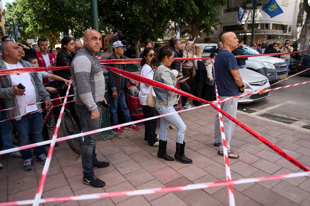 People gather at the site of an Iranian missile strike in Ramat Gan, Israel, Monday, April 6, 2026. (AP Photo/Oded Balilty)