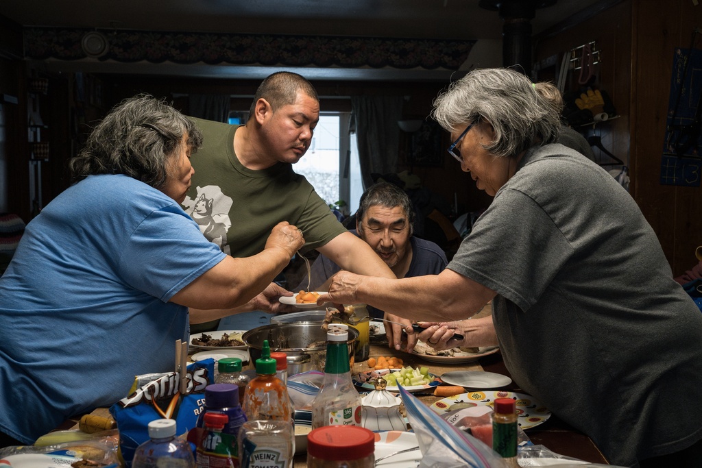 Tristen Pattee and his family eat a meal of beluga whale, bowhead whale, whitefish, moose and seal in Ambler, Alaska, Wednesday, Oct. 2, 2025. (AP Photo/Annika Hammerschlag)