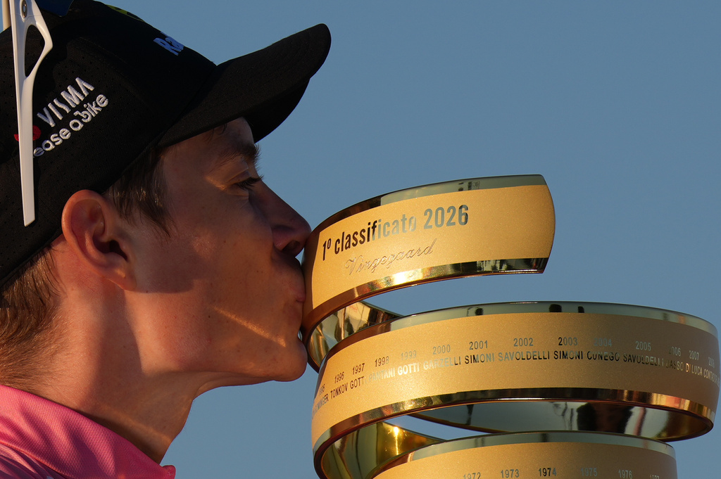 First placed Denmark's Jonas Vingegaard kisses the trophy as he celebrates on the podium at the end of the Giro d'Italia cycling race in Rome Sunday, May 31, 2026. (AP Photo/Andrew Medichini)