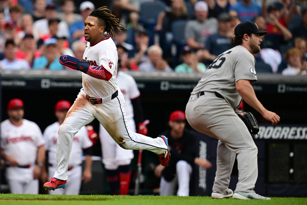 Cleveland Guardians' Jose Ramirez, left, runs home to score a run on an RBI single by Chase DeLauter during the third inning of a baseball game against the New York Yankees, Tuesday, June 9, 2026, in Cleveland. (AP Photo/David Dermer)