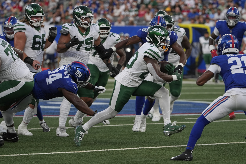 New York Jets running back Breece Hall (20) carries the ball against the New York Giants during the first quarter of an NFL football game, Saturday, Aug. 16, 2025, in East Rutherford, N.J. (AP Photo/Pamela Smith)