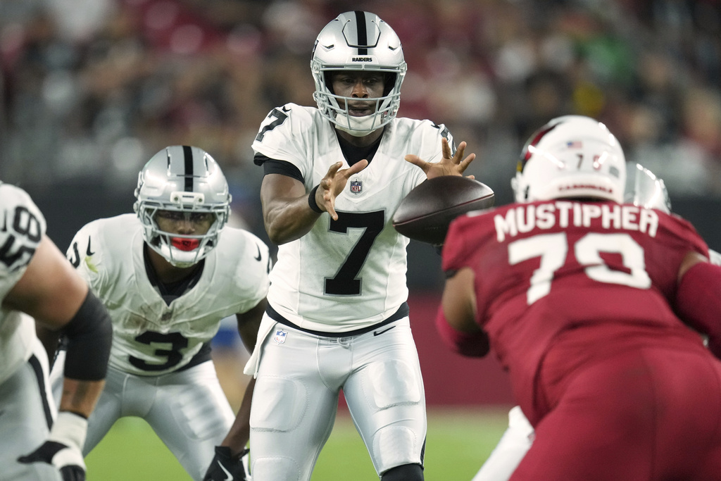 Las Vegas Raiders quarterback Geno Smith (7) takes the snap against the Arizona Cardinals during the first half of an NFL preseason football game, Saturday, Aug. 23, 2025, in Glendale. (AP Photo/Ross D. Franklin)