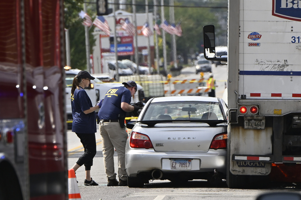 Investigators from the FBI survey the scene where an Immigration and Customs Enforcement officer shot and killed a suspect after the suspect drove his car at the arresting officers, Friday, Sept. 12, 2025, in Franklin Park, Ill. (AP Photo/Paul Beaty)