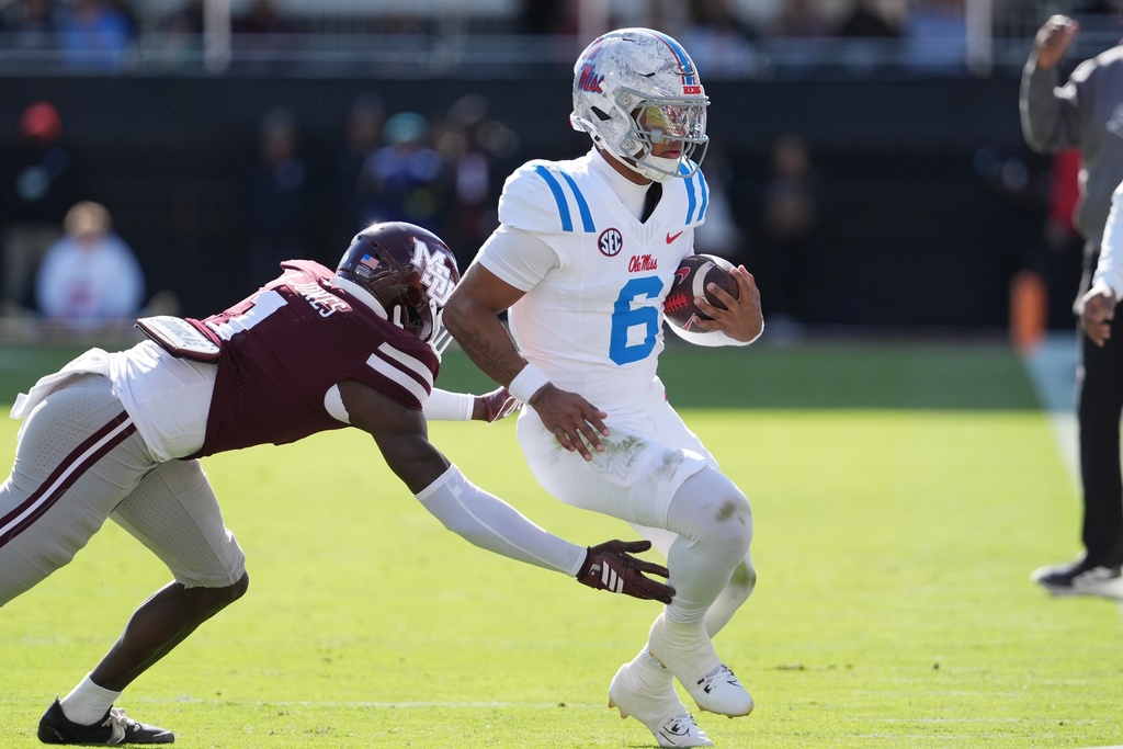 Mississippi quarterback Trinidad Chambliss (6) is pushed out-of-bounds by Mississippi State cornerback Kelley Jones (1) during the first half of an NCAA college football game Frifday, Nov. 28, 2025, in Starkville, Miss. (AP Photo/Rogelio V. Solis)