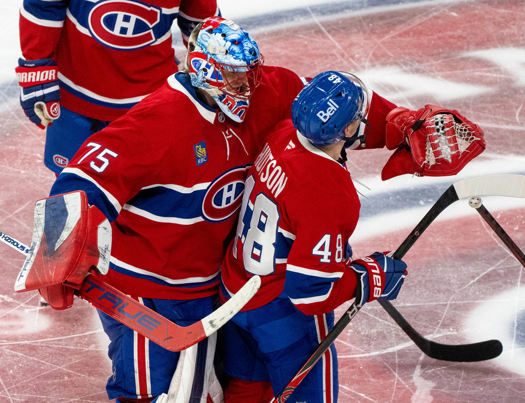 Montreal Canadiens goaltender Jakub Dobes (75) congratulates teammate Lane Hutson (48) after Hutson's winning goal against the Tampa Bay Lightning following overtime of Game 3 in a first-round NHL hockey Stanley Cup playoff series in Montreal, Friday, April 24, 2026. (Christinne Muschi/The Canadian Press via AP)