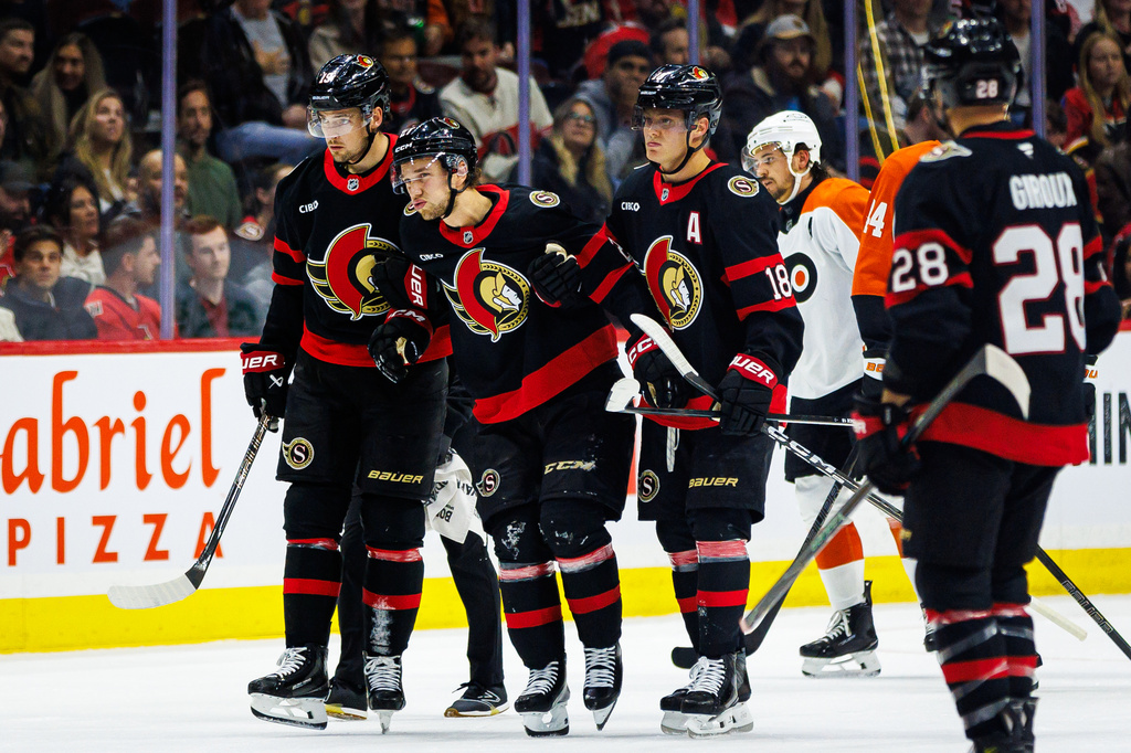 Ottawa Senators' William Eklund, second fom left, is helped off the ice after sustaining an injury during the first period of an NHL hockey game against the Philadelphia Flyers in Ottawa, Ontario, Thursday, Oct. 8, 2026. (Keito Newman/The Canadian Press via AP)