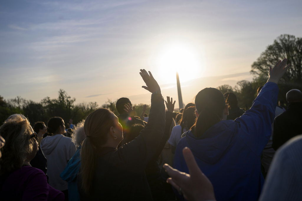 People raise their hands to the sky during an Easter Sunday sunrise prayer service at the Lincoln Memorial, Sunday, April 5, 2026, in Washington. (AP Photo/Rod Lamkey, Jr.)
